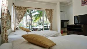 two beds in a bedroom with a large window at Kalamona Seaview in Prachuap Khiri Khan