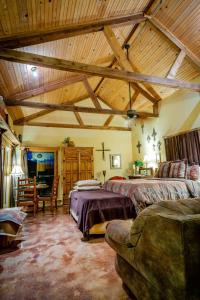 a large room with two beds and a wooden ceiling at Casitas at Madrona Ranch - Casita in Pipe Creek