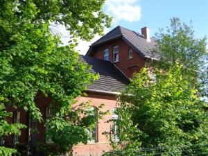 ein rotes Backsteinhaus mit schwarzem Dach in der Unterkunft Bahnhof Droyßig - Übernachten im Denkmal in Droyßig