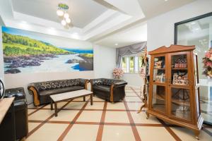 uma sala de estar com um sofá e uma mesa em TOP INN โรงแรมท็อปอินน์ em Maha Sarakham