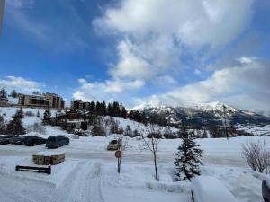 a parking lot covered in snow with mountains in the background at Studio Enchastrayes, 1 pièce, 5 personnes - FR-1-165A-169 in Enchastrayes