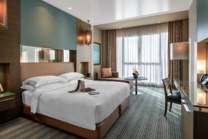 アブダビにあるパーク ロタナ アブダビの大きなベッドとデスクが備わるホテルルームです。