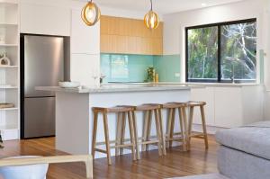 a kitchen with a counter and bar stools at 1 Horizon Terraces Beautifully Styled Duplex Perfect Beach Vibes in Sunshine Beach