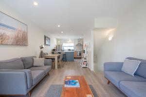 a living room with two blue couches and a table at Spacious Home Near CBD SPA Pool Parking 3BR in Auckland