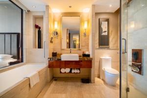 a bathroom with a tub and a sink and a toilet at Crowne Plaza Zhenjiang, an IHG Hotel in Zhenjiang