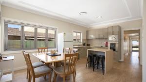 a kitchen and dining room with a table and chairs at Mara Bello - Umina Beach in Umina