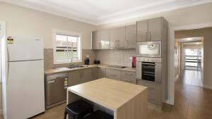 a kitchen with a white refrigerator and a counter top at Mara Bello - Umina Beach in Umina