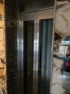 a glass refrigerator with a mirror on a wall at RASA - The Ganges Rishikesh, Ganga Bhumi Apartment in Rishīkesh