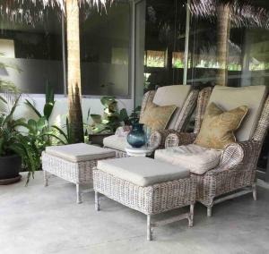 a group of wicker chairs and tables on a patio at Koh Phangan luxurious pool and garden villa in Haad Rin