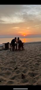 two people sitting at a picnic table on the beach at Sun Smile Beach Koh Jum in Ko Jum