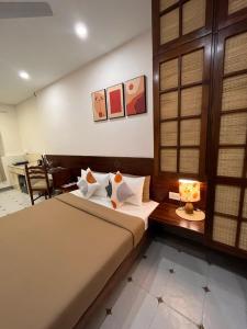a bedroom with two beds and a table with a lamp at Casa Mel in Puducherry