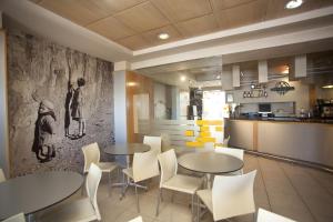 a restaurant with two tables and chairs and a kitchen at Hotel Metropol by Carris in Lugo