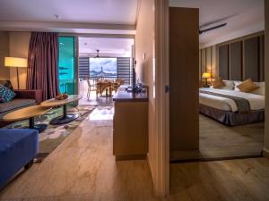 a hotel room with a bed and a living room at Dayang Bay Resort Langkawi in Kuah