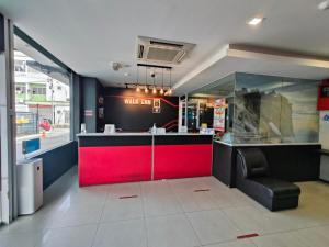 a restaurant with a red counter and a chair at Walk Inn in Miri