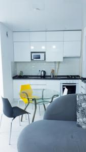 uma cozinha com armários brancos e uma mesa e cadeiras em Апартаменты с шикарным видом на море em Aktau