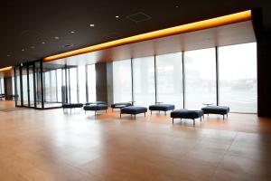 a lobby with chairs and windows in a building at The358 UMI in Fukuoka