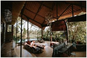 a person sitting on a couch in a pavilion at Firefly Eco Lodge in Ubud