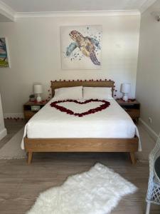 un dormitorio con una cama con un corazón dibujado en ella en SeaTurtle en Clifton Beach