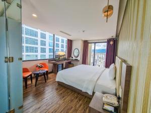 Cette chambre comprend un lit et un bureau. dans l'établissement V Hotel Nha Trang, à Nha Trang