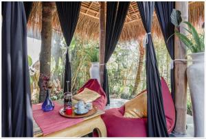 a room with a couch and a table and a window at Firefly Eco Lodge in Ubud