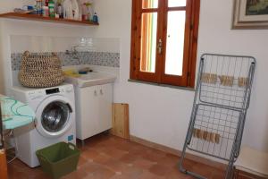 eine Waschküche mit einer Waschmaschine und einem Waschbecken in der Unterkunft Villa Timpone in Guardavalle