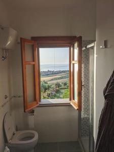 ein Bad mit einem WC und ein Fenster mit Aussicht in der Unterkunft Villa Timpone in Guardavalle