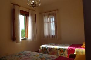 1 dormitorio con 2 camas y 2 ventanas en Villa Timpone, en Guardavalle