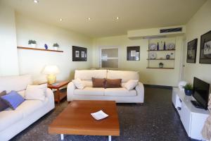 ein Wohnzimmer mit 2 weißen Sofas und einem Couchtisch in der Unterkunft Apartamentos Alquihouse Vilafortuny in Cambrils