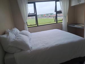 a white bed in a room with a window at 3The Olive Complex Richards Bay 3900 in Richards Bay