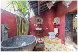 a red bathroom with a tub and a toilet at Firefly Eco Lodge in Ubud +130 photos
