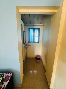 a hallway with a sink and a window in a room at Coco land - Near Nagaon Beach, Alibag in Alibaug