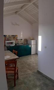 a kitchen with a table and a kitchen with green cabinets at Il Veliero in Fiskardo