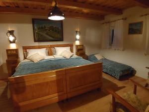 een slaapkamer met een groot houten bed en 2 eenpersoonsbedden bij POČITNIŠKA HIŠA PRLEČKA in Miklavž pri Ormožu