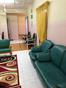 a living room with a green couch and chairs at irdahusna homestay 