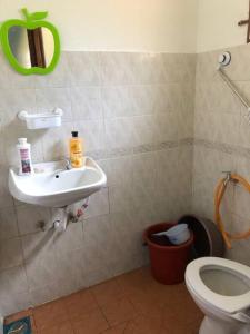 ein Bad mit einem Waschbecken und einem WC in der Unterkunft irdahusna homestay 
