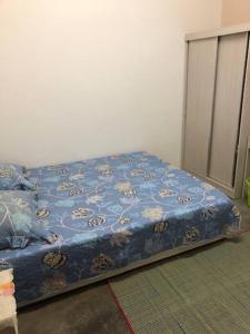 a bed in a room with a blue comforter at irdahusna homestay 