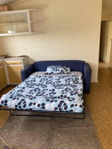 a bed in a room with a blue couch at Very basic Cabin next to Long Beach & National park in Coffin Bay