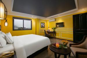 Pokój hotelowy z białym łóżkiem i biurkiem w obiekcie Eden Central Hotel & Spa w mieście Sa Pa