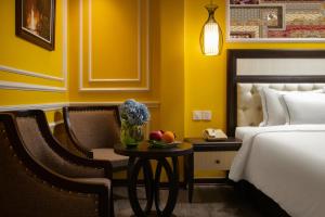 a hotel room with a bed and a table with a chair at Eden Central Hotel & Spa in Sapa