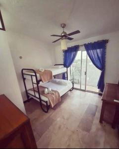 カンクンにあるBonita casa Moon Penthouse en Cancúnのベッドルーム1室(ベッド2台、シーリングファン付)