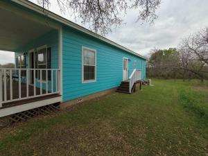 a blue house with a porch and a yard at Luxury cottage near lake Belton - WiFi A/C in Belton