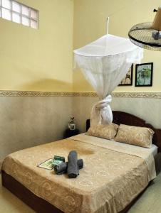 a bedroom with a bed with a umbrella on it at Stay in Kampot in Kampot