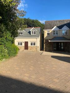 a large white house with a brick driveway at Cornish country getaway in Callington