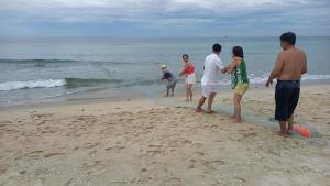 Un groupe de personnes debout sur la plage dans l'établissement Ngoc Lan Homestay 2, 