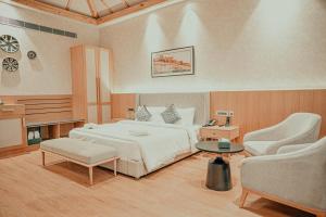 1 Schlafzimmer mit einem Bett, 2 Stühlen und einem Tisch in der Unterkunft Pushkara Resort and Spa, Pushkar in Pushkar