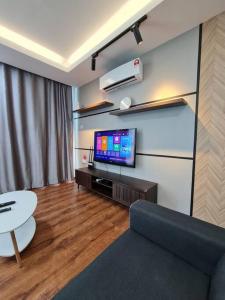een woonkamer met een bank en een flatscreen-tv bij V' BROS VivaCity J2.1 [GOT DRYER] in Kuching