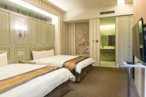 een hotelkamer met 2 bedden en een televisie bij Renyi Lake Hotel in Fanlu