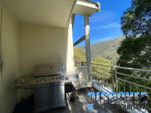 a outdoor kitchen with a stove on a balcony at Inala 3 in Thredbo