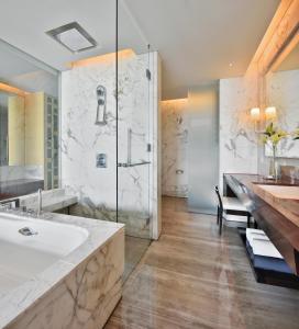 La salle de bains est pourvue d'une baignoire, d'un lavabo et d'une douche. dans l'établissement JW Marriott Hotel Chandigarh, à Chandigarh