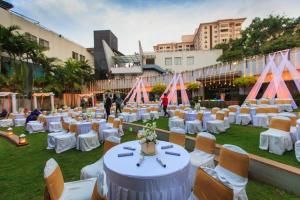 a group of tables with white tables and chairs in a field at THE WOODROSE in Bangalore